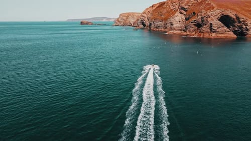 The jet ski runs in the direction of the rock on turquoise water. Aerial view.
