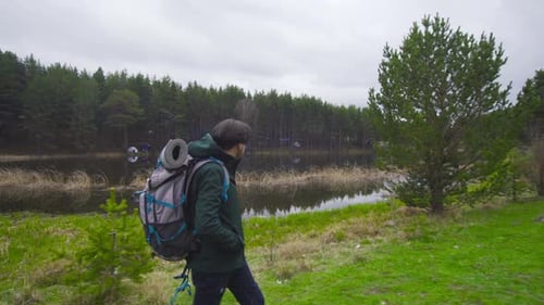 Young Adult Hiker Walking By a Lake