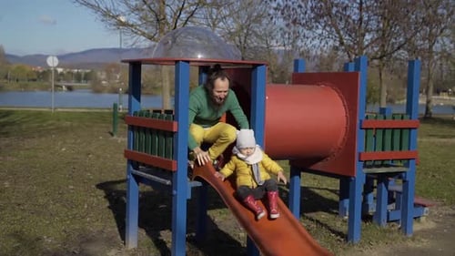 Father playing with infant son in public playground, Zagreb, Croatia.