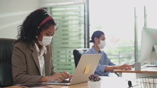 Group of Asian team business people working in office with new normal social distancing lifestyle.