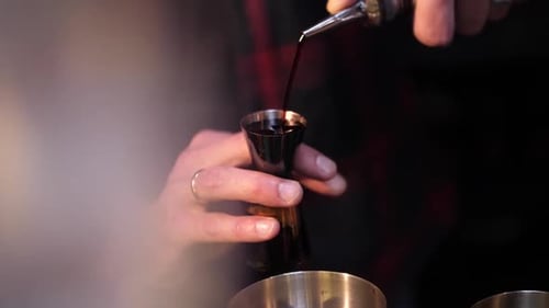 Making an alcoholic cocktail. The bartender pours a cocktail. Cocktail in a glass.