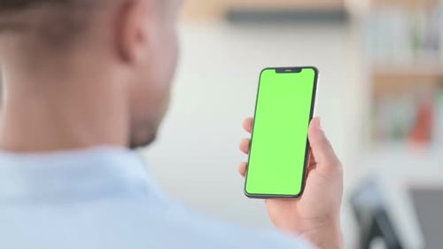 African Man Using Smartphone with Green Chroma Key Screen