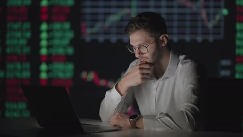 Young Man Working Late with Stock Data