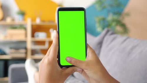 Close-up of Lady's Hands Holding Smartphone with Mock-up Green Screen Swiping