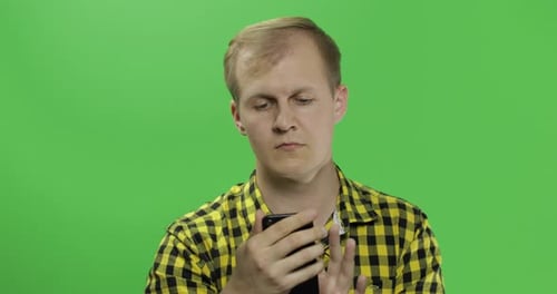 Young Adult Using Cell Phone on Green Screen