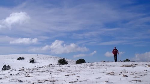 Climber Reaches the Top of Snowy Mountain on Sunny Winter Day