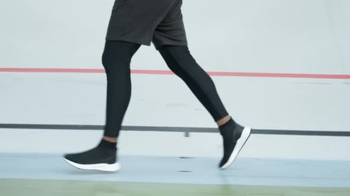 Male Jogger Training at Stadium Track. Athlete Legs Running on Racetrack