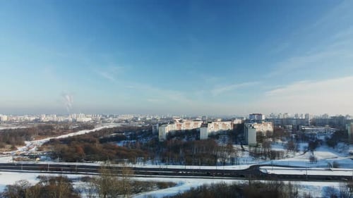 Flight over the city block. Winter cityscape. The city highway is visible.