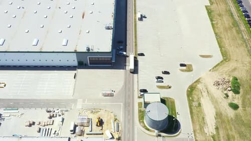 Aerial Shot of Industrial Warehouse Loading Dock where Many Truck with Semi Trailers Load Merchandis