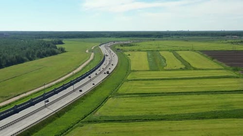 Asphalt Speedway with Cars Through Green Field. Aerial View From Drone