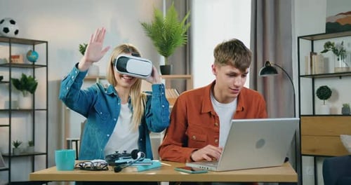 Chica rubia con auriculares de realidad virtual que ve una visión futurista cuando es un chico guapo y positivo