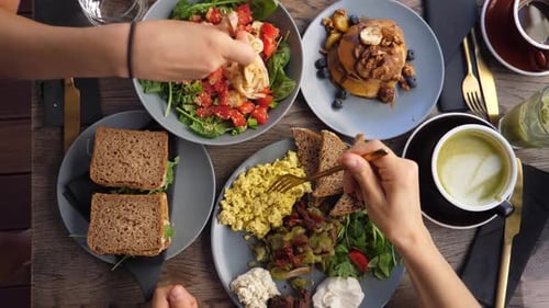 Top View of Hands Eating Healthy Organic Vegan Breakfast of Full English, Pasta Salad and Vegan