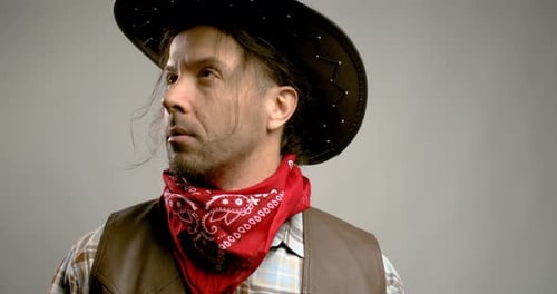 Man Wearing a Cowboy Hat and Bandana