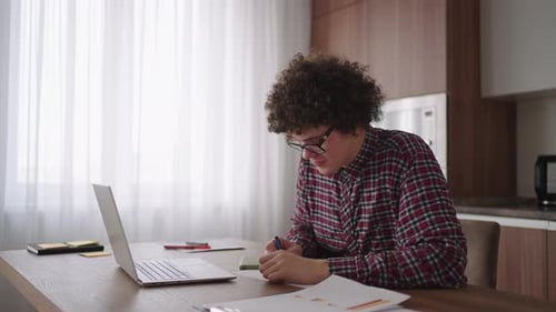 Young Adult Working at Home Office on Laptop