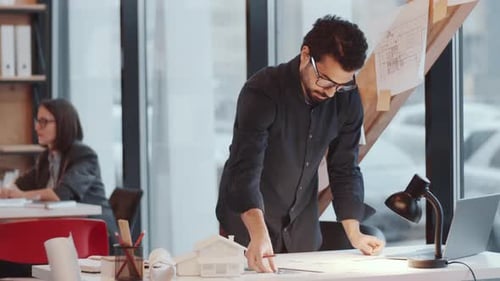 Middle Eastern Male Architect Drawing Floor Plan on Paper at Office Desk