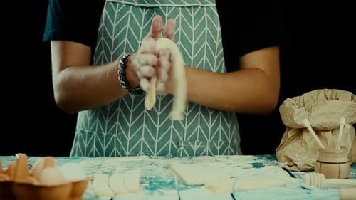 Chef Rolls and Cuts Dough on Flour-covered Table