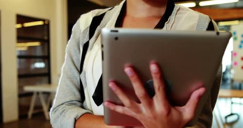 Smiling Woman Holding Tablet in Modern Workplace