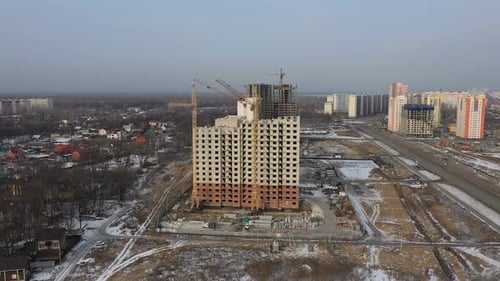 Construcción de un gran edificio de apartamentos. Las grúas de torre y los constructores construyen una casa de ladrillo Vista desde