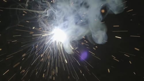 Nahaufnahme eines Metallschweißers, der im Werk mit einem Lichtbogenschweißgerät zum Schweißen von Stahl arbeitet