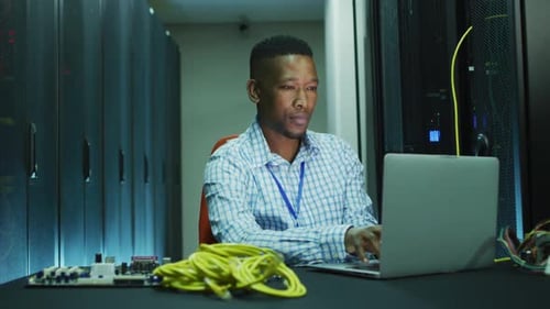 Young Adult Works on Laptop in Data Center