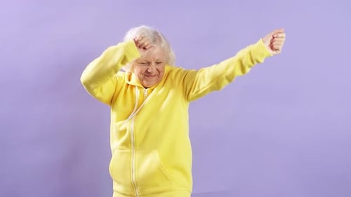 Energetic Senior Woman Dancing in Yellow Jumpsuit