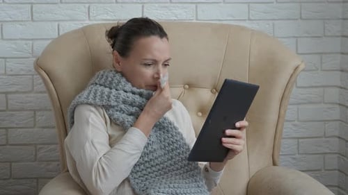 Sick Woman Using Tablet in Armchair