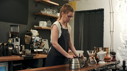 Barista making hand brewed coffee adding grinded coffee