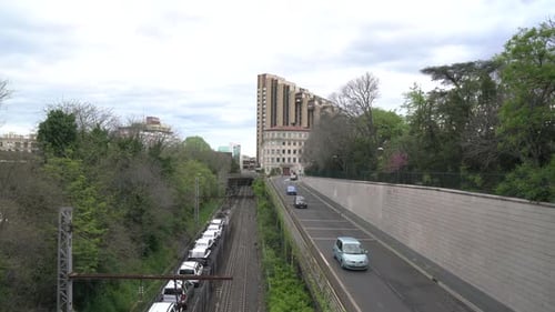Train Transporting Cars Alongside Highway