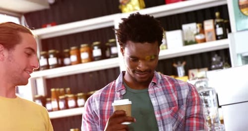 Men Use Technology Together at a Coffee Shop