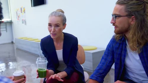 Coworkers Smiling and Discussing Business in Modern Office