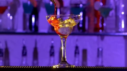 Barman Making Cocktail in a Glass Using Ice, Sweet Syrup and Alcohol Liquid, on Bar, Slow Motion