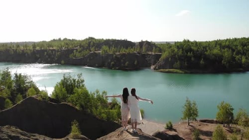 Nice Cinematic Incredible View of Two Women on Top of Mountain Against Background of Blue Lake on