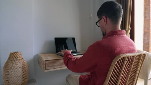 Man Working on Laptop at Desk Indoors