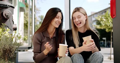 Two Young Women Talking and Drinking Coffee