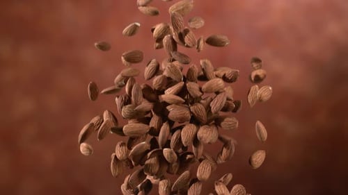 Almonds Falling on Red Background