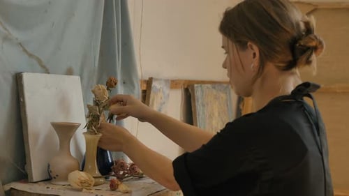 Woman Artist Makes Composition with Dried Roses in Studio