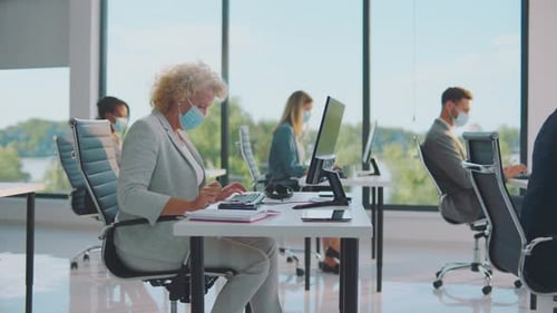 Adults Working in Modern Office Wearing Face Masks