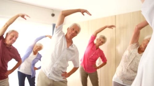 Seniors Exercising Together with Instructor in Bright Room