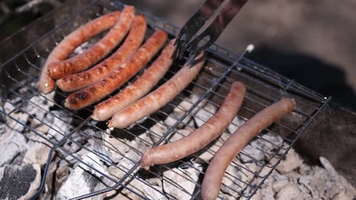Closeup View of Tasty Sausages Grilling on Charcoal Grill Grate