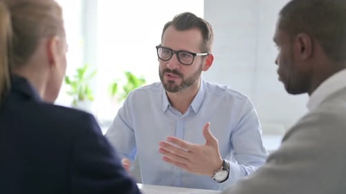 Businessman Scolding to Mixed Race Business People in Office