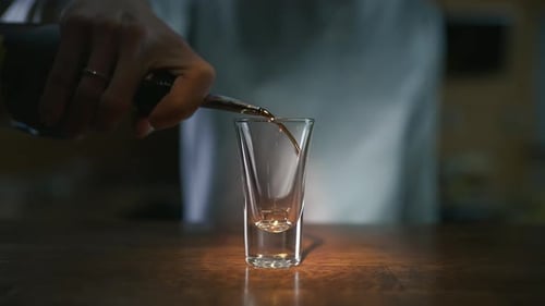 Close Up Video of Pouring Dark Liquor To the Glass in Slowmotion, Pouring Alcohol in a Bar