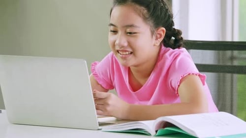A girl doing her school work with laptop. Distance learning and online education concept.