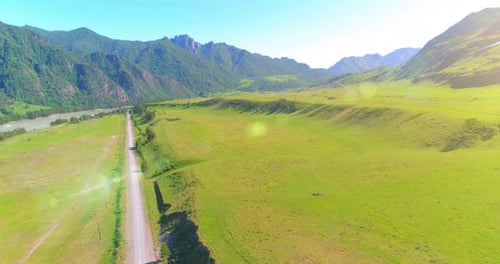 Aerial Rural Mountain Road and Meadow at Sunny Summer Morning. Asphalt Highway and River.