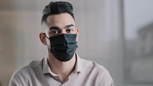Young Adult Wearing Black Mask Looking at Camera