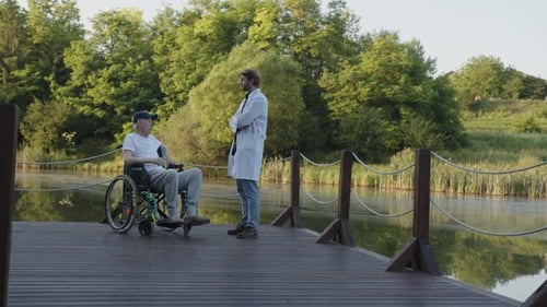Senior Man in Wheelchair Talking with Doctor