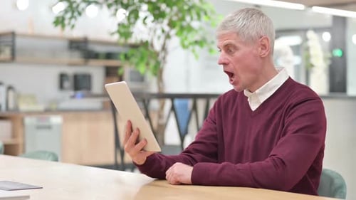 Mature Adult Reacts to News on Tablet