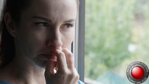 Woman Using Nasal Spray by a Window
