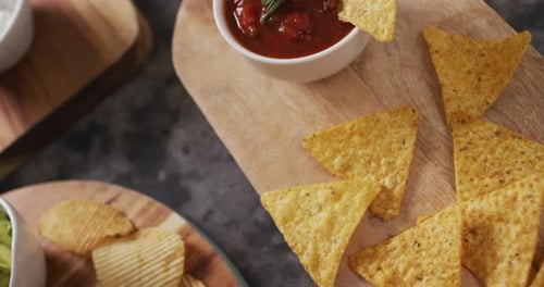 Vista de cerca de una variedad de patatas fritas y salsas en bandejas de madera sobre superficie negra