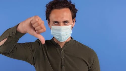 Young Adult Gives Thumbs Down Wearing Mask