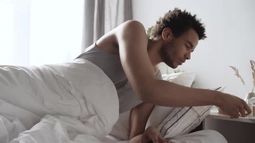 Young Man Wakes Up and Uses Inhaler